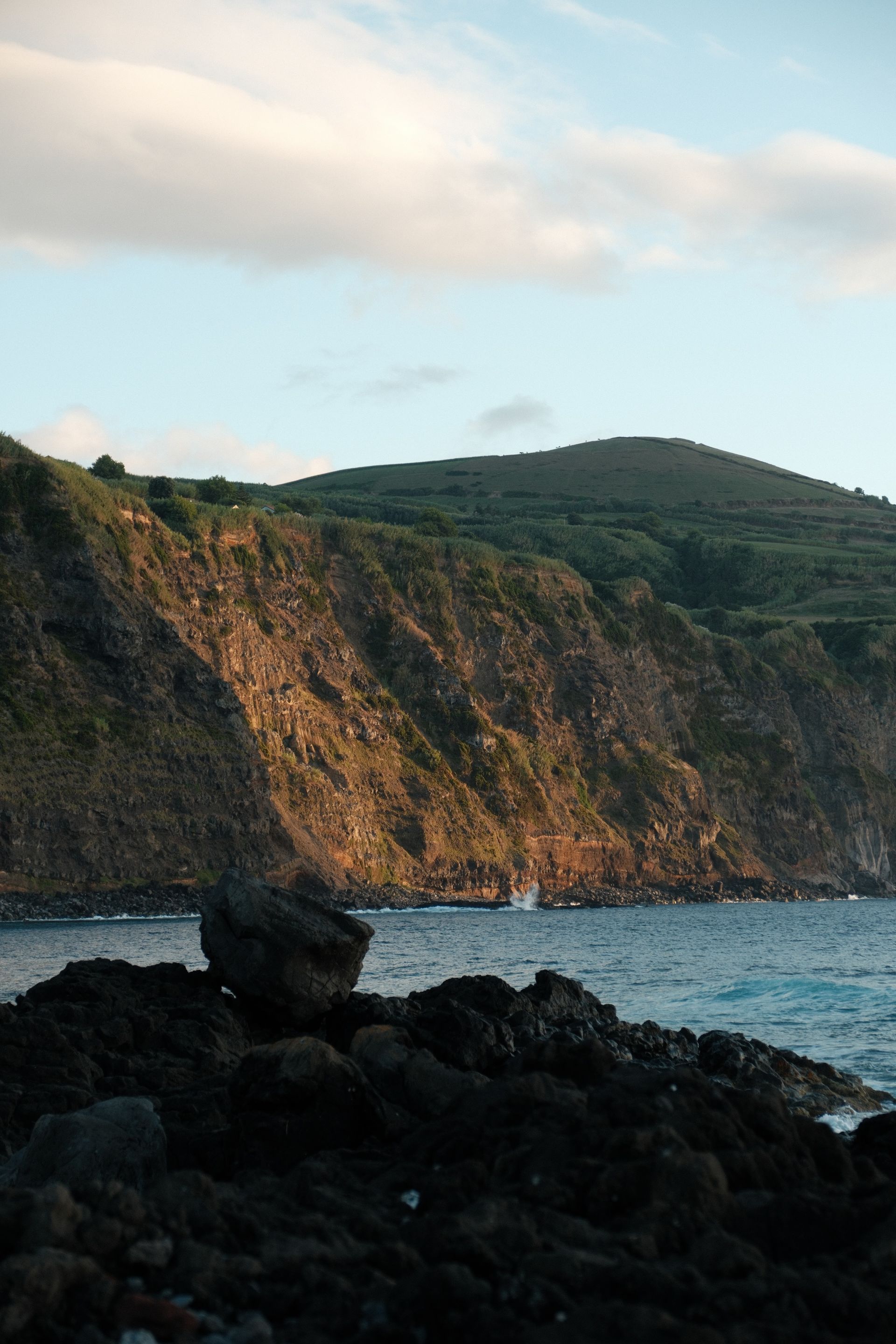 Von der Sonne angestrahlte Steilkippe in einer Bucht.