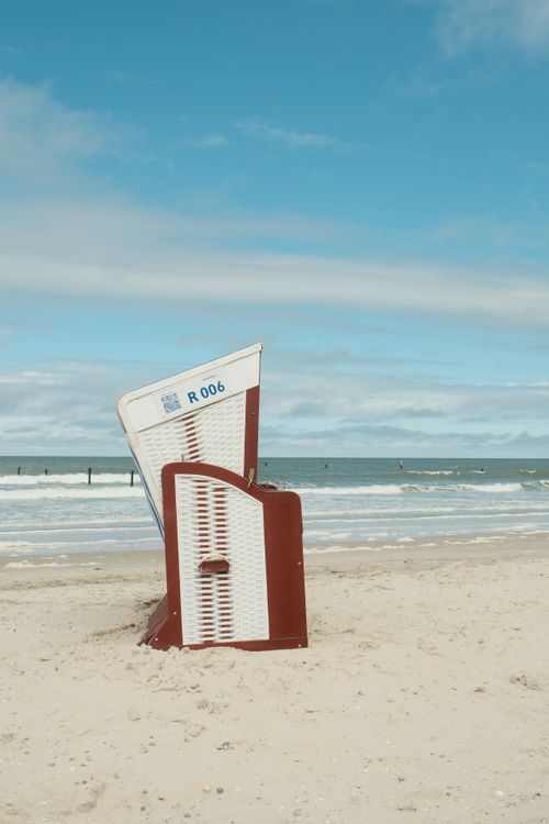 Ein Strandkorb am Strand, im Hintergrund das Meer