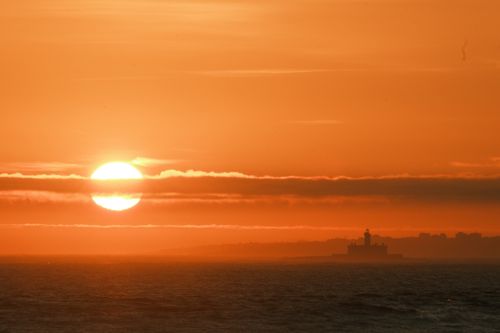 Die untergehende Sonne malt den Himmel Orange.